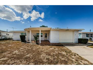 Mid-century ranch home with carport and landscaping at 1551 Derrick St, Holiday, FL 34690