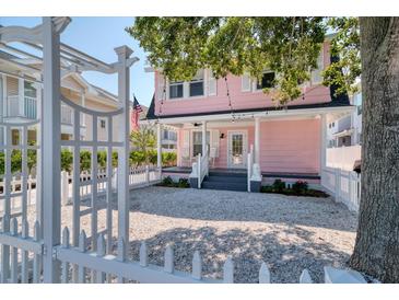 Charming pink house with white picket fence and gravel driveway at 963 Highland Ave, Dunedin, FL 34698
