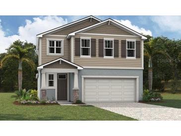Two-story home with attached garage, landscaping, and large windows at 5700 Spivey Ct, Wesley Chapel, FL 33545