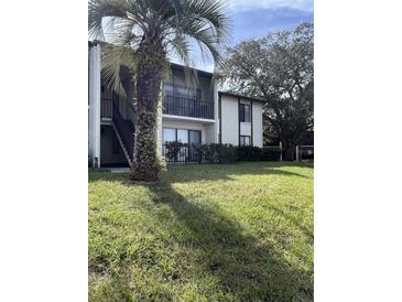 Two-story condo building with balconies and lush landscaping at 2688 Pine Ridge N Way # D1, Palm Harbor, FL 34684