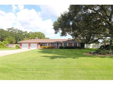 Ranch-style brick home with a large yard and mature oak tree at 5302 Turkey Creek Rd, Plant City, FL 33567