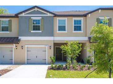 Tan and gray two-story townhome with two-car garage and small front yard at 17399 Nectar Flume Dr, Land O Lakes, FL 34638
