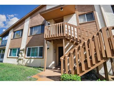 Condo building exterior with wooden staircase and landscaping at 4028 Davit Dr # 4028, New Port Richey, FL 34652