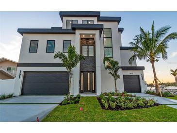Stunning, modern home with a two-car garage and beautiful landscaping at 2832 W Vina Del Mar Blvd, St Pete Beach, FL 33706