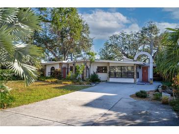 Mid-century modern home with landscaped yard and gated entrance at 2406 S Clark Ave, Tampa, FL 33629