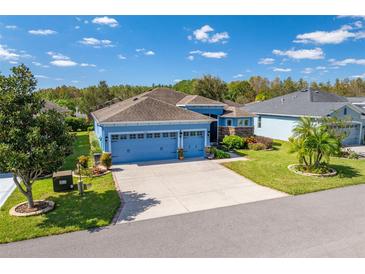 Two-story home with a three-car garage and manicured lawn at 10415 Hyannisport Loop, San Antonio, FL 33576