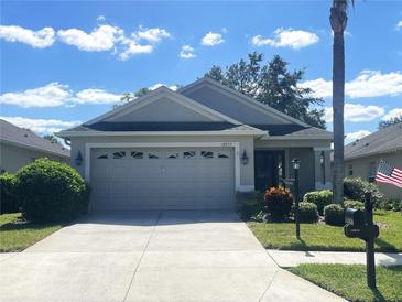 Single-story home with two-car garage and landscaped yard at 18833 Bent Pine Dr, Hudson, FL 34667