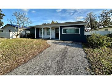 A charming bungalow with a gray exterior and a gravel driveway at 1882 Maryland Ne Ave, St Petersburg, FL 33702