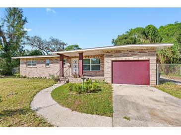 Brick ranch house with a red garage door and landscaped yard at 404 E Morgan St, Brandon, FL 33510