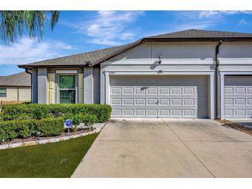 Two-car garage and well manicured landscaping at 13285 Crest Lake Dr, Hudson, FL 34669