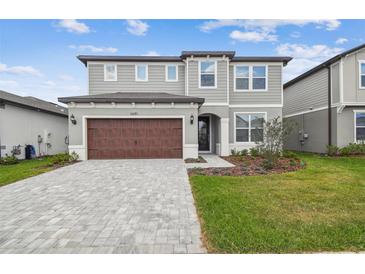 Charming two-story home with a landscaped yard and a welcoming, brick-paved driveway at 6681 Michael Favor Way, Wesley Chapel, FL 33545