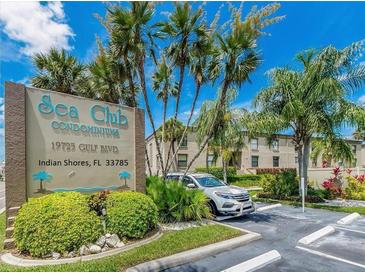 Sea Club Condominiums entrance with parking and lush landscaping at 19725 Gulf Blvd # 20, Indian Shores, FL 33785
