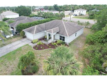 A single-story home featuring manicured landscaping, a neutral paint scheme and an attached two-car garage at 2857 Brewster Rd, North Port, FL 34288