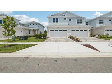 Charming two-story townhome with two-car garage and a well manicured lawn and blue skies at 31895 Anchor Point Dr, Wesley Chapel, FL 33545