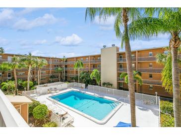 Refreshing community pool with surrounding lounge chairs and palm trees at 12760 Indian Rocks Rd # 1071, Largo, FL 33774