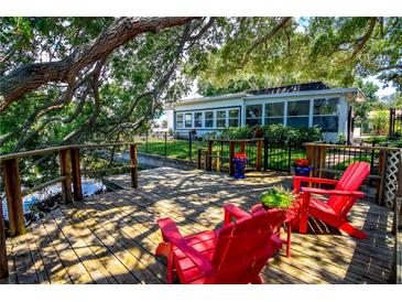 Wooden deck with red Adirondack chairs, ideal for enjoying the view at 10931 Clara Ln, St Petersburg, FL 33708