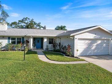 Single-story home with a blue door and landscaped yard at 112 N Bay Hills Blvd, Safety Harbor, FL 34695