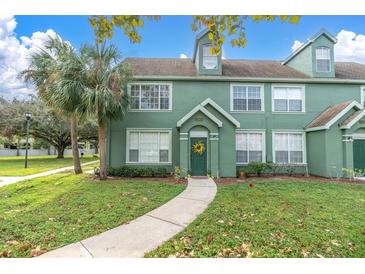 Inviting townhome featuring a lush lawn, walkway, and a charming door wreath at 10404 White Lake Ct # 10404, Tampa, FL 33626