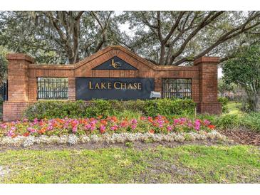 Lake Chase community entrance with brick pillars, iron gates, and landscaped flowerbeds at 10404 White Lake Ct # 10404, Tampa, FL 33626