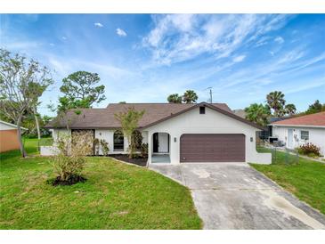 Newly renovated home with a landscaped lawn and attached garage at 4501 Harrington St, Port Charlotte, FL 33948