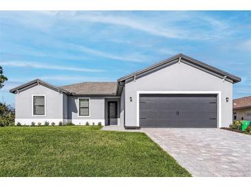 Charming single-story home features a gray facade, well-manicured lawn, and a gray brick driveway at 5321 Crestline Ter, Port Charlotte, FL 33981