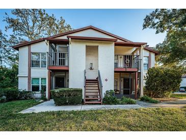 Two-story condo building with balconies and landscaping at 3455 Countryside Blvd # 52, Clearwater, FL 33761