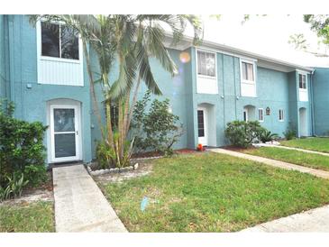 Light blue townhome exterior with grassy yard at 117 114Th N Ave # 117, St Petersburg, FL 33716
