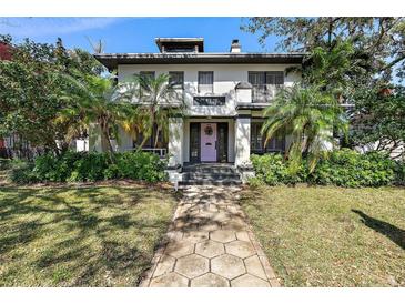 Charming two-story home with lush landscaping, a hexagonal stone walkway, and unique architectural details at 515 20Th Ne Ave, St Petersburg, FL 33704