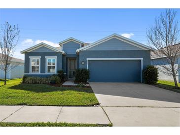 Single-story home with blue siding, two-car garage, and well-manicured lawn at 8852 Prairie Creek Dr, New Port Richey, FL 34655