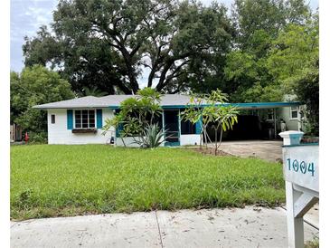 Charming ranch style home with teal accents and lush lawn at 1004 E Fern St, Tampa, FL 33604