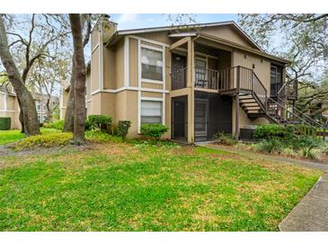 Two-story condo with private entrance, stairs, and lush landscaping at 14323 Hanging Moss Cir # 102, Tampa, FL 33613