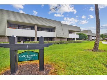 Exterior view of Canterbury Lodge 7 building with landscaping at 36750 Us Highway 19 N # 04208, Palm Harbor, FL 34684