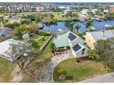 Beautiful waterfront home featuring a green metal roof, solar panels, and dock access to canal at 1104 Kingfish Pl, Apollo Beach, FL 33572