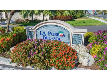 La Puerta Del Sol community sign surrounded by colorful flowers and landscaping at 5825 Puerta Del Sol S Blvd # 170, St Petersburg, FL 33715