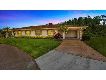 Charming single story home with a well maintained lawn, mature landscaping, and a two-car carport at 2104 Hembury Pl # 33, Sun City Center, FL 33573
