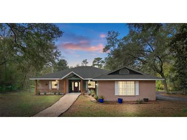Charming single-story home with brick accents, covered porch and mature trees in a peaceful wooded setting at 5143 Culbreath Rd, Brooksville, FL 34601