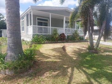 Charming single-story home featuring a quaint porch and well-maintained landscaping, nestled amongst mature palms at 140 Independence Ave # 11, Palm Harbor, FL 34684