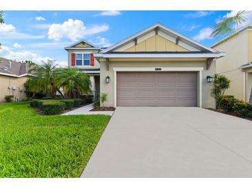 Two-story house with a two-car garage and landscaped lawn at 9157 Bella Vita Cir, Land O Lakes, FL 34637