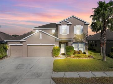 Two-story home with attached two-car garage and landscaping at 11339 Tayport Loop, New Port Richey, FL 34654