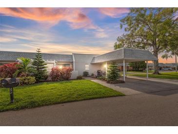 Condo exterior at sunset with carport and landscaping at 3942 Trophy Blvd, New Port Richey, FL 34655