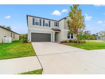 Two-story house with gray exterior and a dark garage door at 1911 Fan Aloe Way, Ruskin, FL 33570