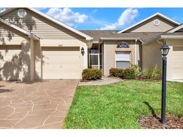 Beige exterior with a two-car garage and landscaping at 2403 Nantucket Green Ct # 0, Sun City Center, FL 33573