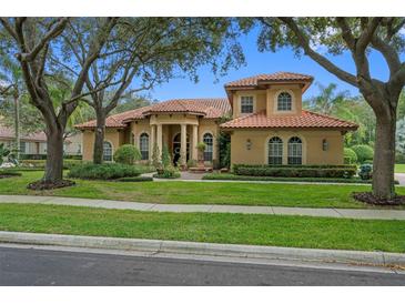 Two-story house with tile roof and landscaping at 531 Isleworth Close, Tarpon Springs, FL 34688