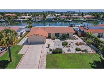 Charming waterfront home with a tile roof, landscaped yard, and a private dock on a sunny day at 4380 44Th S St, St Petersburg, FL 33711