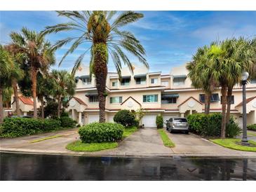 Front view of charming townhouses with lush landscaping and palm trees at 4630 Mirabella Ct, St Pete Beach, FL 33706