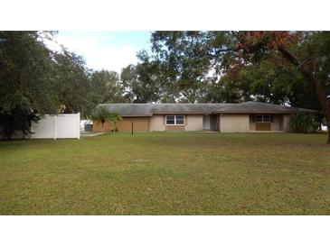Ranch-style home with a spacious lawn and white fence at 3706 Joe Sanchez Rd, Plant City, FL 33565