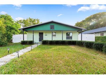 Light green house with a dark green roof, walkway, and well-maintained lawn at 1013 E 28Th Ave, Tampa, FL 33605