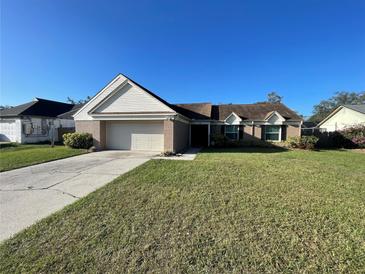 Brick ranch house with a two-car garage and well-maintained lawn at 1309 Peachfield Dr, Valrico, FL 33596