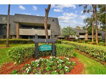 Caroustie Lodge building exterior with landscaping and signage at 36750 Us Highway 19 N # 03127, Palm Harbor, FL 34684