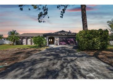 Single story home with attached garage and lush landscaping at 5181 Horseshoe Ne Pl, St Petersburg, FL 33703